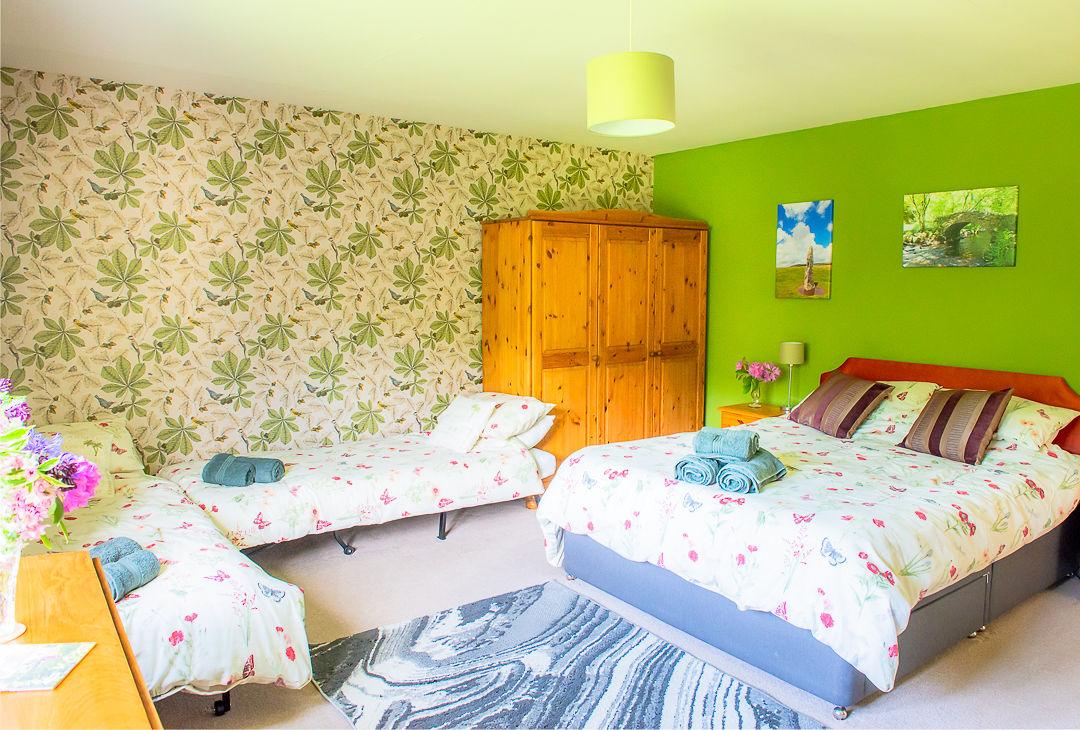 Bovey bedroom set up as family room with king size double with and 2 single beds