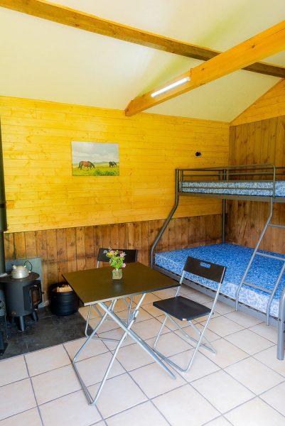 Eco-bothy interior Eco-bothy interior showing log burner, triple bunk and foldaway dining table and chairs