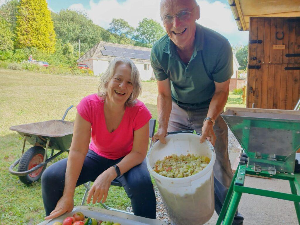 Michelle and Kevin with a large bucket of crushed apples about to be pressed.  Apple pressing is normally a late September Autumn activity