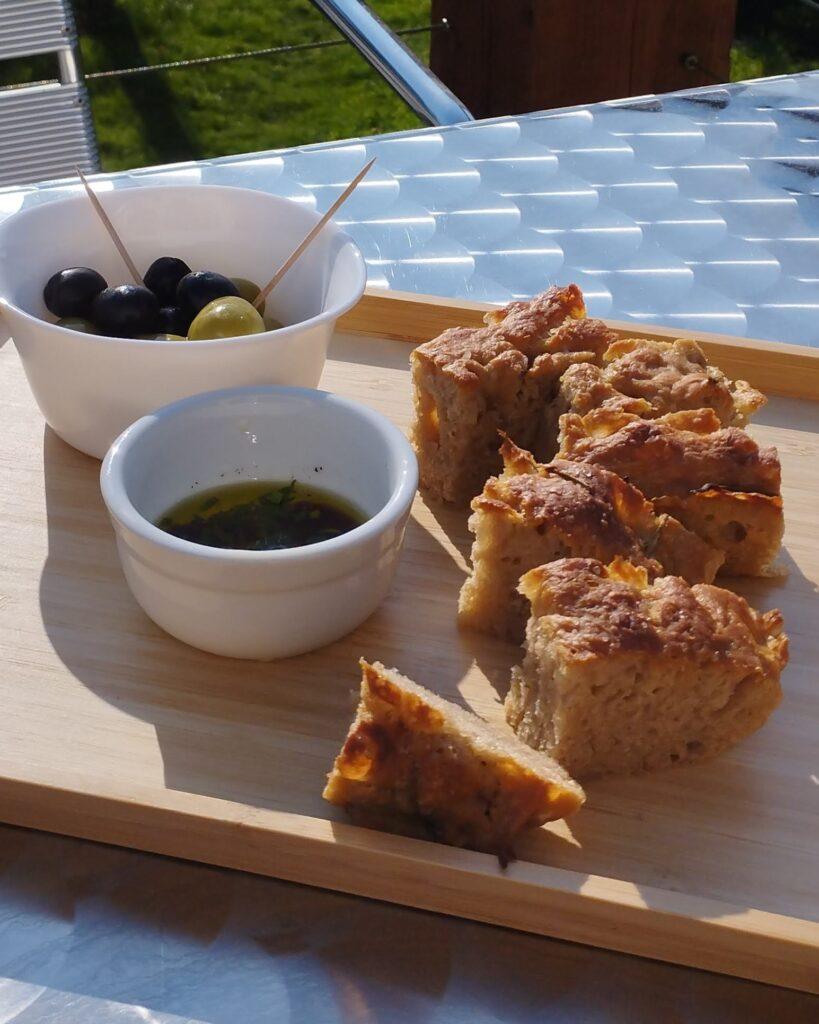 Focaccia bread with balsamic vinegar and olive oil dip and bowl of olives